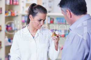 Young trainee looking at a bottle of pills