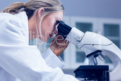 Science student looking through microscope in the lab