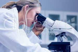 Science student looking through microscope in the lab