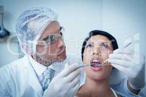 Male dentist examining womans teeth