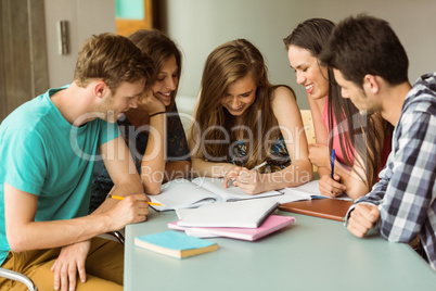 Smiling friends sitting studying together