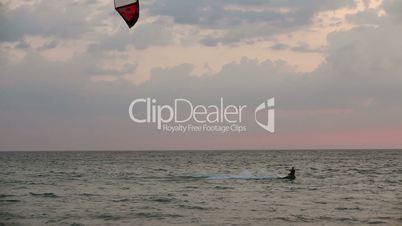 Kite surfer sailing  on the sea at sunset