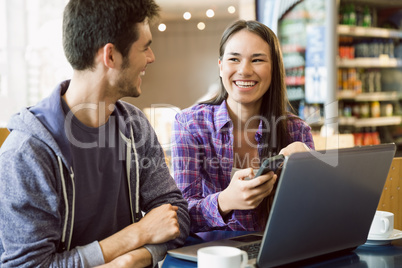 Young students doing assignment on laptop together