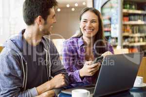 Young students doing assignment on laptop together