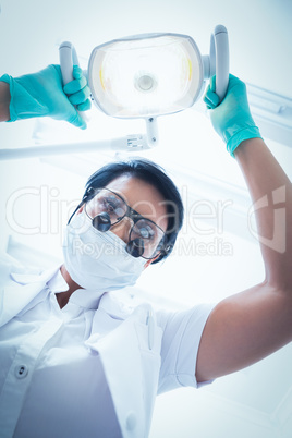 Female dentist adjusting light