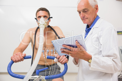 Doctor showing tablet pc to man doing fitness test