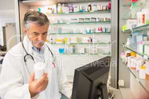 Senior pharmacist using the computer