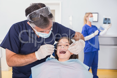 Pediatric dentist examining her young patient