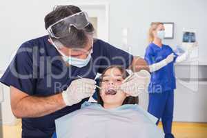 Pediatric dentist examining her young patient