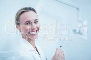 Smiling female dentist holding injection