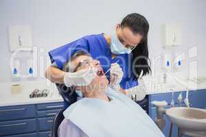 Dentist examining a patient with tools
