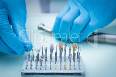 Gloved hands picking dental tools