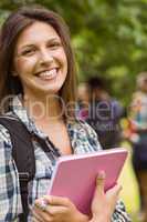 Portrait of a smiling student with a shoulder bag and holding bo