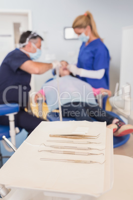 Dentist and his dental assistant examining a young patient