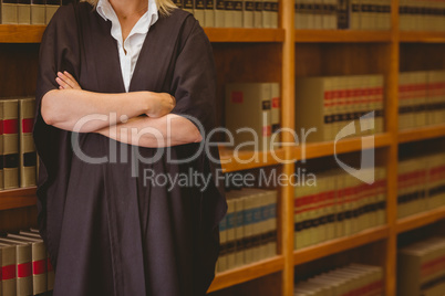 Lawyer leaning on shelf with arms crossed