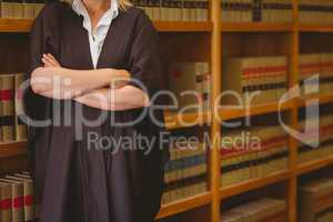 Lawyer leaning on shelf with arms crossed