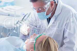 Dentist in surgical mask and gloves holding tool