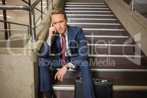 Stressed businessman sitting on steps
