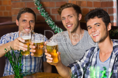 Happy friends toasting with pints of beer on patricks day