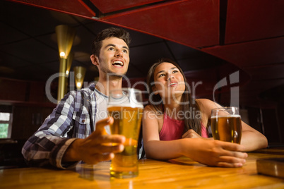 Smiling friends drinking beer together