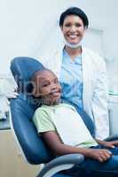 Portrait of female dentist examining boys teeth