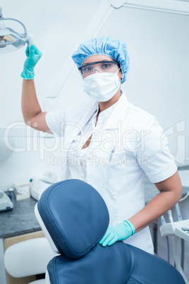 Female dentist wearing surgical mask and safety glasses