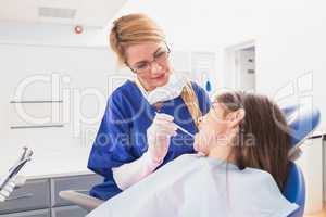 Pediatric dentist examining her young patient