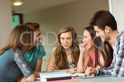 Smiling friends sitting studying together