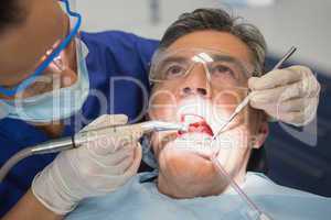 Dentist examining a patient with tools and light