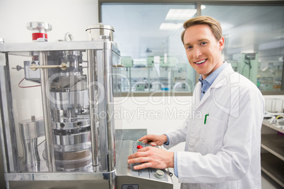 Happy pharmacist pressing button on machine