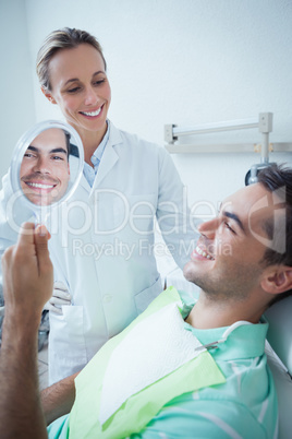 Smiling young man looking at mirror