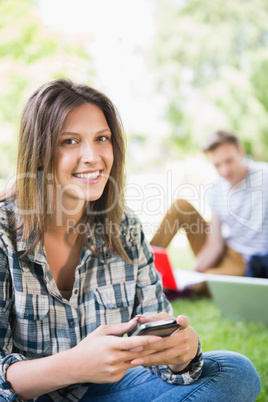 Happy students sitting outside on campus