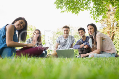 Happy students sitting outside on campus