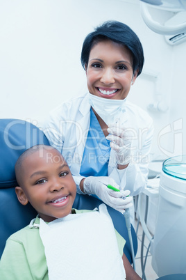 Portrait of smiling female dentist examining boys teeth