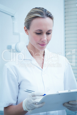 Female dentist checking reports