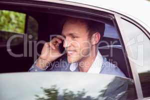Young man talking on phone in limousine