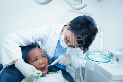 Female dentist examining boys teeth