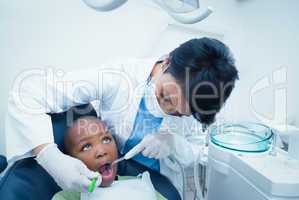 Female dentist examining boys teeth