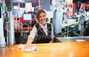 Pretty barmaid wiping down bar