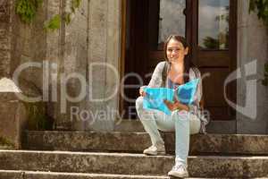 Smiling student sitting and holding book