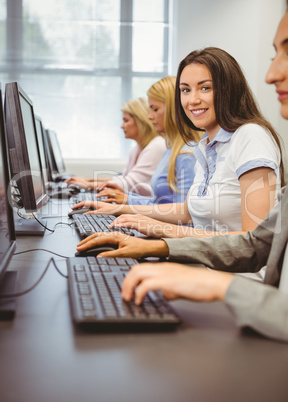 Happy woman in computer room smiling at camera