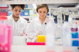 Pretty science students using pipette