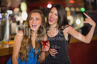 Pretty friends drinking cocktails together