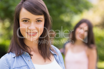 Pretty student smiling at camera outside on campus