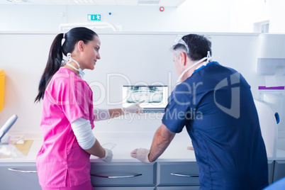 Dentist and assistant looking at x-ray together