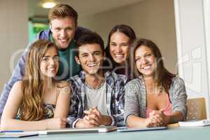 Portrait of smiling friends posing near their laptop