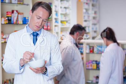 Focused pharmacist using mortar and pestle