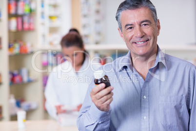 Smiling man with a bottle of pills