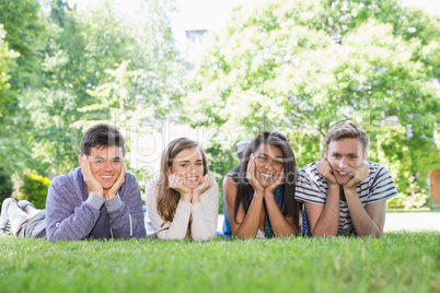 Happy students using laptop outside