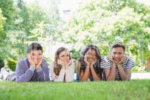 Happy students using laptop outside